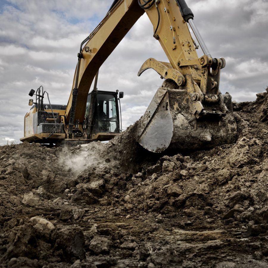 An excavator digging into the ground with its large bucket